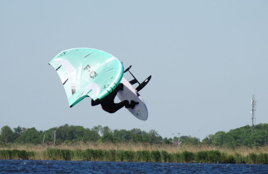 Figure aérienne avec aile F-One Strike V5 pendant une session de wing foil