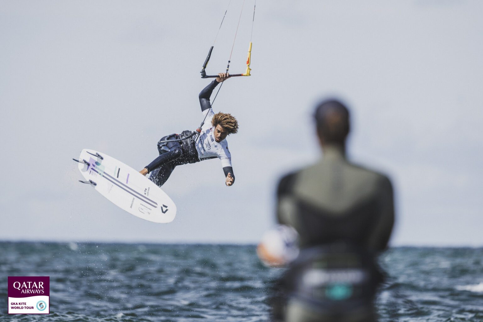 salto radicale kitesurf con tavola da surf su onde