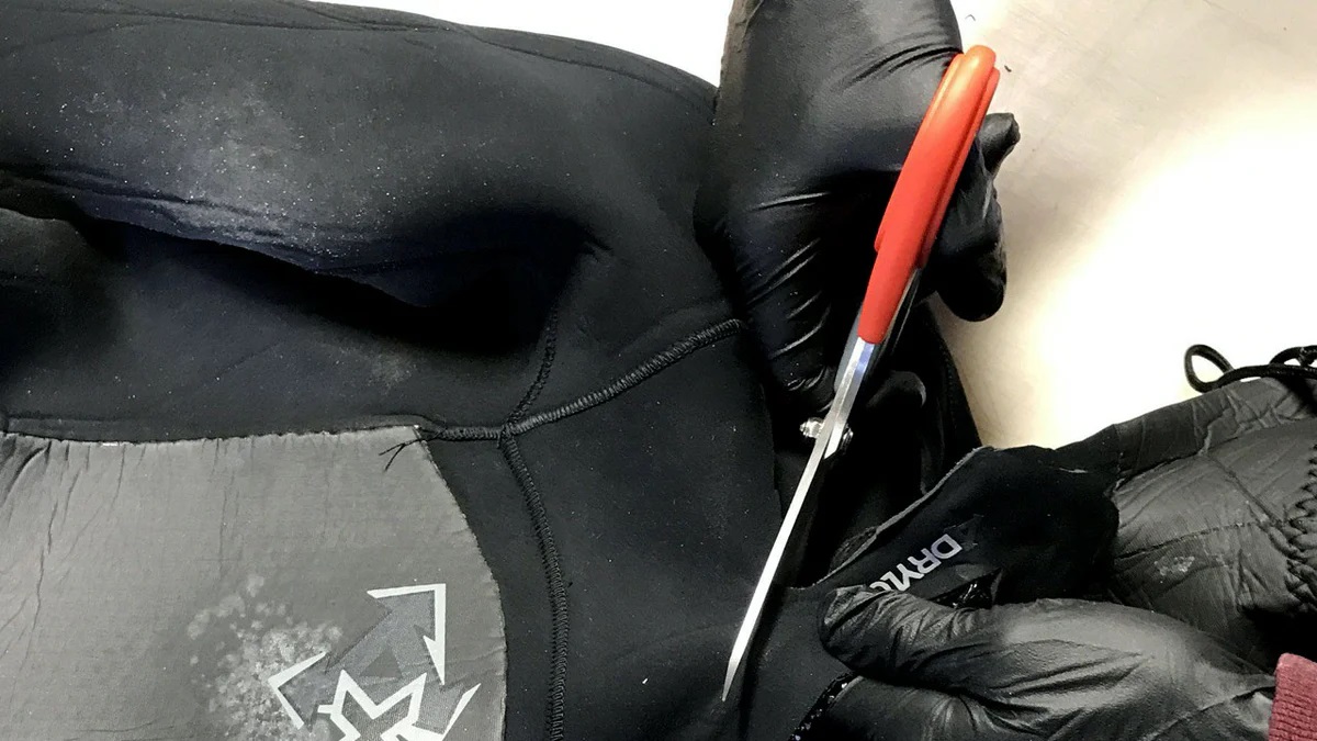wetsuit repair with scissors and gloves
